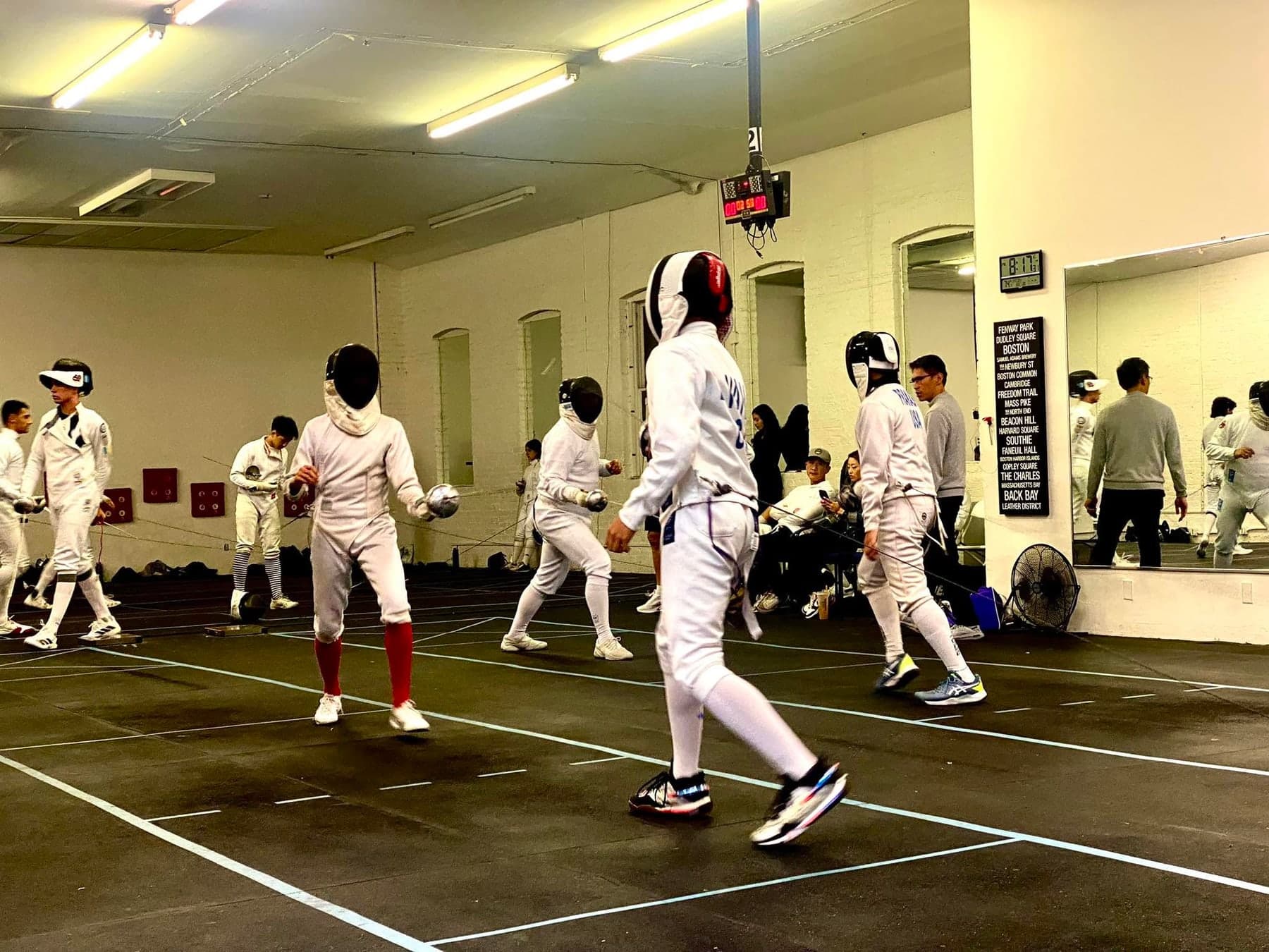 Fencers bouting across several strips at Marin Fencing Academy